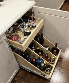 an open drawer in a kitchen filled with bottles