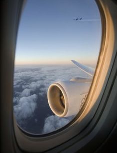 an airplane window looking out at the clouds