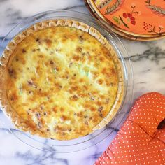 a pie sitting on top of a table next to an oven mitt and orange polka dot napkin