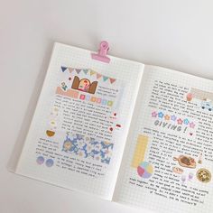 an open notebook with stickers on it and a clipboard attached to the page