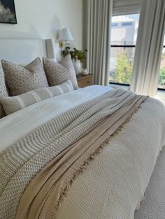 a large bed sitting in a bedroom next to a window