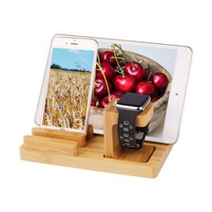 an apple watch and cell phone on a wooden stand with a bowl of cherries in the background