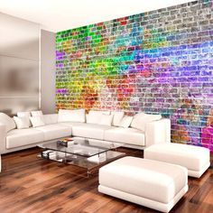 a living room filled with white furniture next to a rainbow wallpapered brick wall