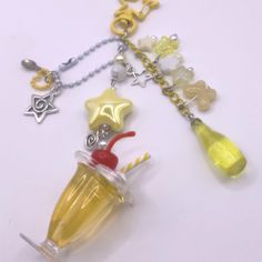 a yellow glass filled with liquid sitting on top of a white table next to a silver chain