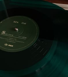 a green vinyl record sitting on top of a wooden table