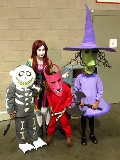 three children in halloween costumes standing next to each other