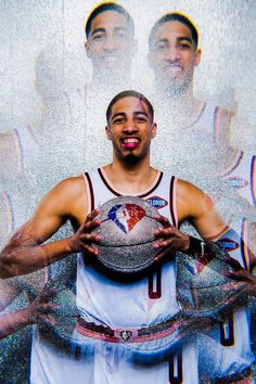 a basketball player holding a ball in front of his face with two other players behind him