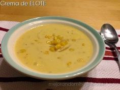 a bowl of corn chowee on a table with a spoon and napkin next to it