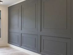 an empty room with gray walls and white trim