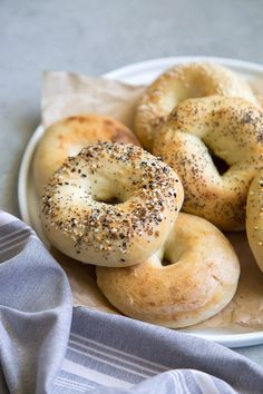 bagels with poppy seed sprinkles are on a plate next to a napkin