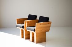 two wooden chairs sitting side by side on a white floor