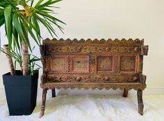 an old wooden bench next to a potted plant on a white furnishing