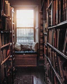 a room filled with lots of books next to a window