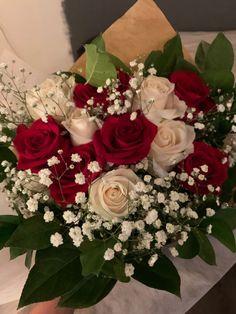 a bouquet of red and white roses on a table