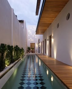 an indoor swimming pool in the middle of a building with lights on it's sides