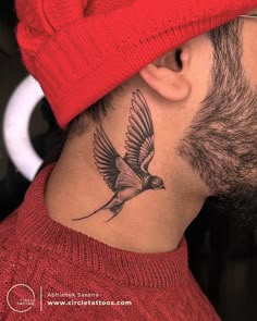 a man with a bird tattoo on his neck