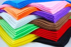 a stack of folded towels sitting on top of each other in different colors and patterns