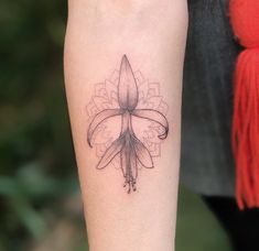 a tattoo on the arm of a woman with a flower in her left hand and a tatoo