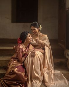 two women sitting next to each other on steps