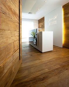 a room with wood floors and white walls, including a plant on the counter top