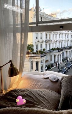 a bed sitting in front of a window next to a lamp