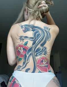 the back of a woman's body with tattoos on her upper and lower half