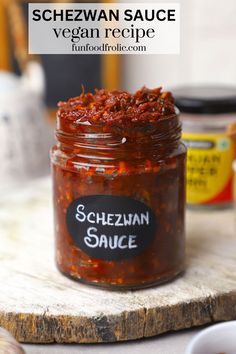 a jar filled with sauce sitting on top of a wooden table