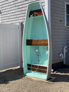 a small boat shaped like a toilet in front of a house with a door open