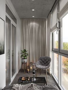 a living room filled with furniture and large windows next to a window covered in curtains