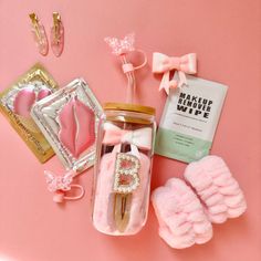 pink items are laid out on a pink surface, including hair clips and other accessories