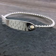 This fish bracelet has a twisted sterling silver bracelet band with a detailed hand-carved fish that hooks into a 14k gold eye. Stack this with other bracelets or wear it alone for a simple statement. Please measure your wrist to find your correct size (instructions here). Fish Bracelet, Fish Hook Bracelet, Fishing Bracelet, Fish Jewelry, Metal Smithing, Hook Bracelet, Silver Fish, Sterling Bracelets, Bracelet Diy