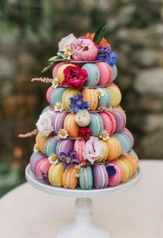 colorful macaroons stacked on top of each other in a tiered cake stand