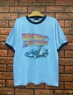 "Vintage 90s Back To The Future American Legendary Sci Fi 1985 Movie T Shirt / Science Fiction / Cult Movie / Vintage Movie T Shirt Size L Condition : Good Used Size on tag : M fits L Colour : Blue Brand : Thunder Creek Measurement : Armpit to armpit -21\" Length - 26.5\" Material : Old Cotton Made In: Usa THE SHIPPING POLICY 1. Item will be shipped in 3-5days after payment. The shipping cost $20 is via DHL Express Service. It will take 3-5days working day or more for delivery, depends on your c Movie Tshirt Designs, Film T Shirt, Blue Crew Neck Top With Vintage Print, 90s Shirts Vintage, Aesthetic Clothes 90s, 90s T Shirts, Back To The Future Shirt, 80s Aesthetic Outfits, Movie Tshirts