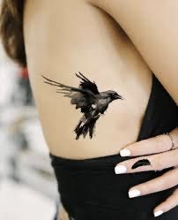 a woman's arm with a bird tattoo on the back of her left shoulder