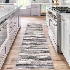 a kitchen with white cabinets and gray rug