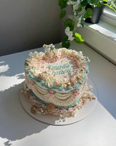 a heart shaped cake sitting on top of a white table next to a potted plant