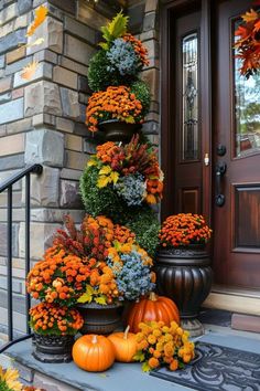 an outdoor fall decoration with pumpkins and flowers