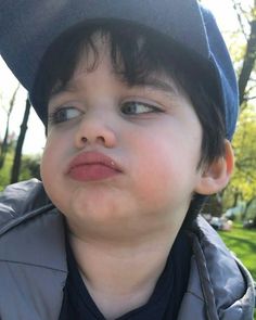 a young boy wearing a blue hat and jacket