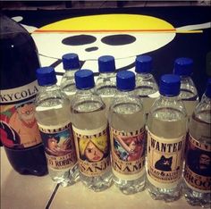 several bottles of water are lined up on a counter top next to a cartoon character