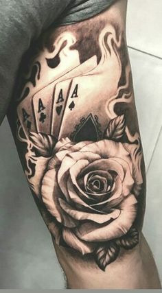 a man's arm with a rose and playing cards on it