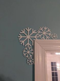 a snowflake cut out on the wall next to a mirror