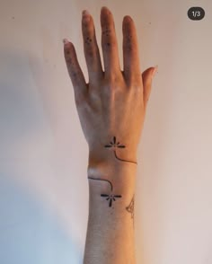 a person's arm with a tattoo on it and a hand holding the wrist