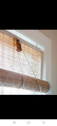 an image of a window with blinds in the windowsill and some wires hanging from it