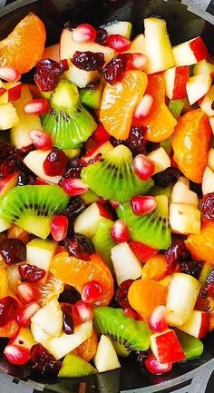 fruit salad with kiwis, oranges, and cranberries in a skillet