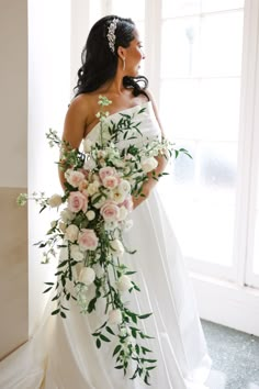 a woman in a white dress holding a bouquet of flowers