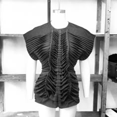 a black and white photo of a mannequin's torso with ruffles