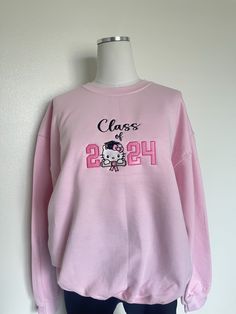 Class of 2024 senior gradation gift, Embroidered class of  2024 Sweatshirt, kitty sweater 8 oz., 50% Cotton/ 50% Polyester  Our sweatshirts run in unisex sizes, if between sizes or for a loose fit I recommend to size up. Make sure to choose your size accordingly! A size chart with measurements is listed, see photos. Washing Instructions: - Turn garment inside out - Hand wash or delicate was cycle - Wash in cold water - Use mild detergent - Do NOT use bleach - Air dry to avoid any shrinkage - Iro Senior Sweater, Senior Sweaters, Class Of 2023 Sweater, Casual Crew Neck Sweatshirt For Graduation, Senior Barbie Sweatshirt, Class Of 2023 Pink, Pink Crew Sweatshirt With Embroidered Graphics, Senior Sweatshirts Ideas 2025, Senior Sweatshirts Ideas