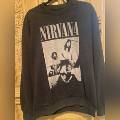 New Rare Vintage 90s The Nirvana Sitting Unisex Sweatshirt Is An Officially Licensed Sweatshirt That Features A Distressed, Black Pigment Dye-Wash Design. It's Made From 60% Recycled Cotton And 40% Recycled Polyester. Size Large. Kurt Cobain Not Only Had Amazing Talent For Writing, Singing, And Playing His Music, But He Was Also Known As A Trend Setter In The Grunge Era. From His Old Band Tees With Cardigans, Distressed, Holy Blue Jeans, To His Converse. To Many’s Surprise Converse Used To Be A Cheap Shoe, That Kurt Made Famous When Back Then Chuck Taylor’s Were The Designer. So Throw On This Sweatshirt, Some Distressed, Holy Jeans, And Colored Converse And Be The Envy Of Everyone In Lov Nirvana Hoodie, Colored Converse, Holy Jeans, Nirvana Shirt, Black Pigment, Cheap Shoes, Kurt Cobain, Band Tees, Nirvana