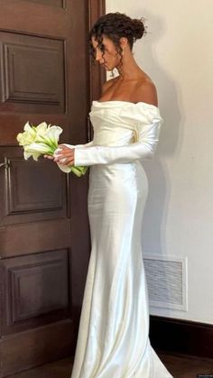 a woman in a white dress holding flowers