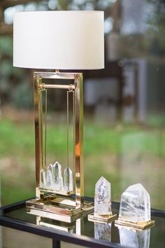 a lamp sitting on top of a table next to some crystal rocks and a white shade